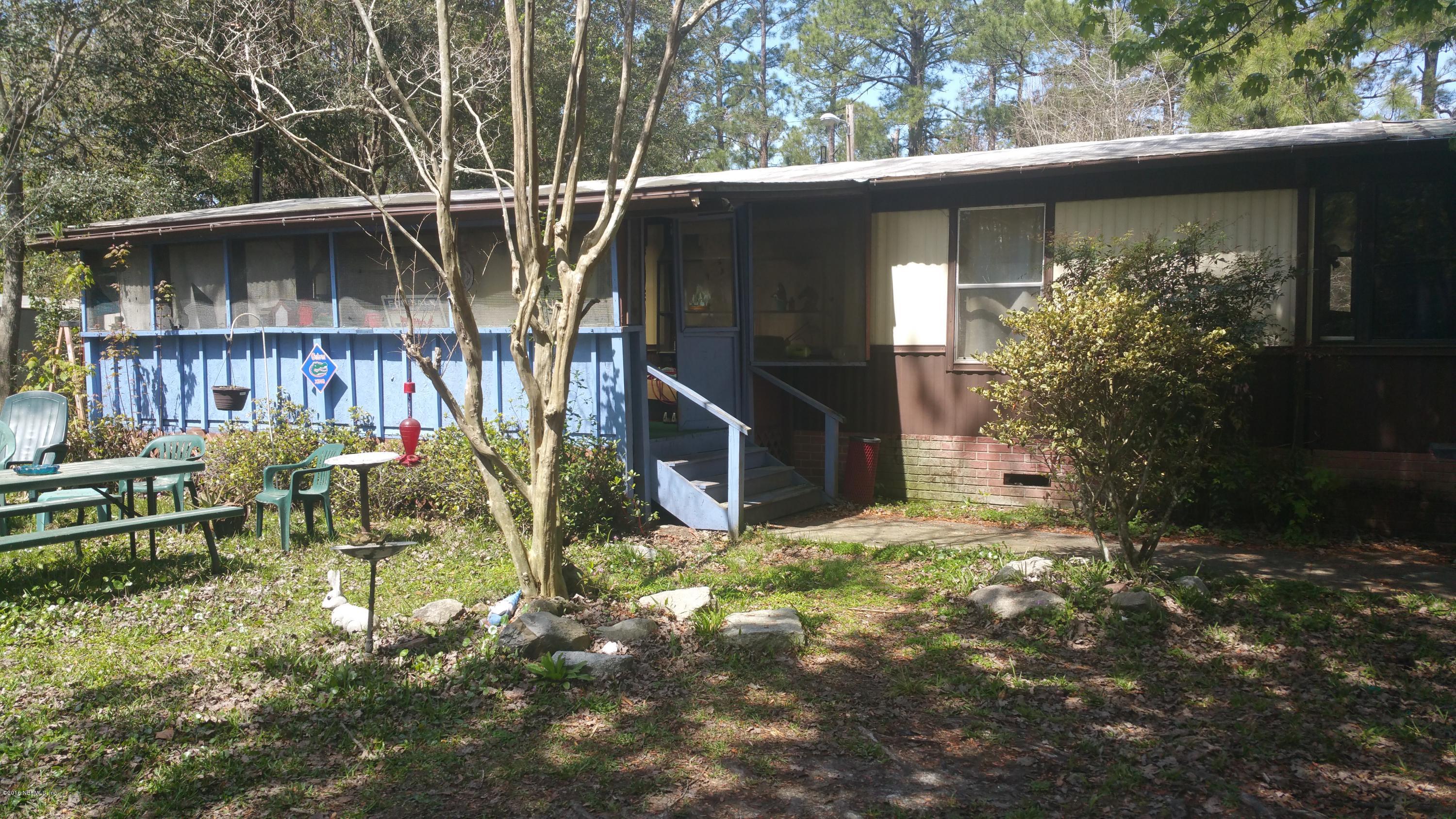 1640 Jake Road Jacksonville, FL 32226 - Photo 3 of 13 a view of backyard with table and chairs potted plants and large tree