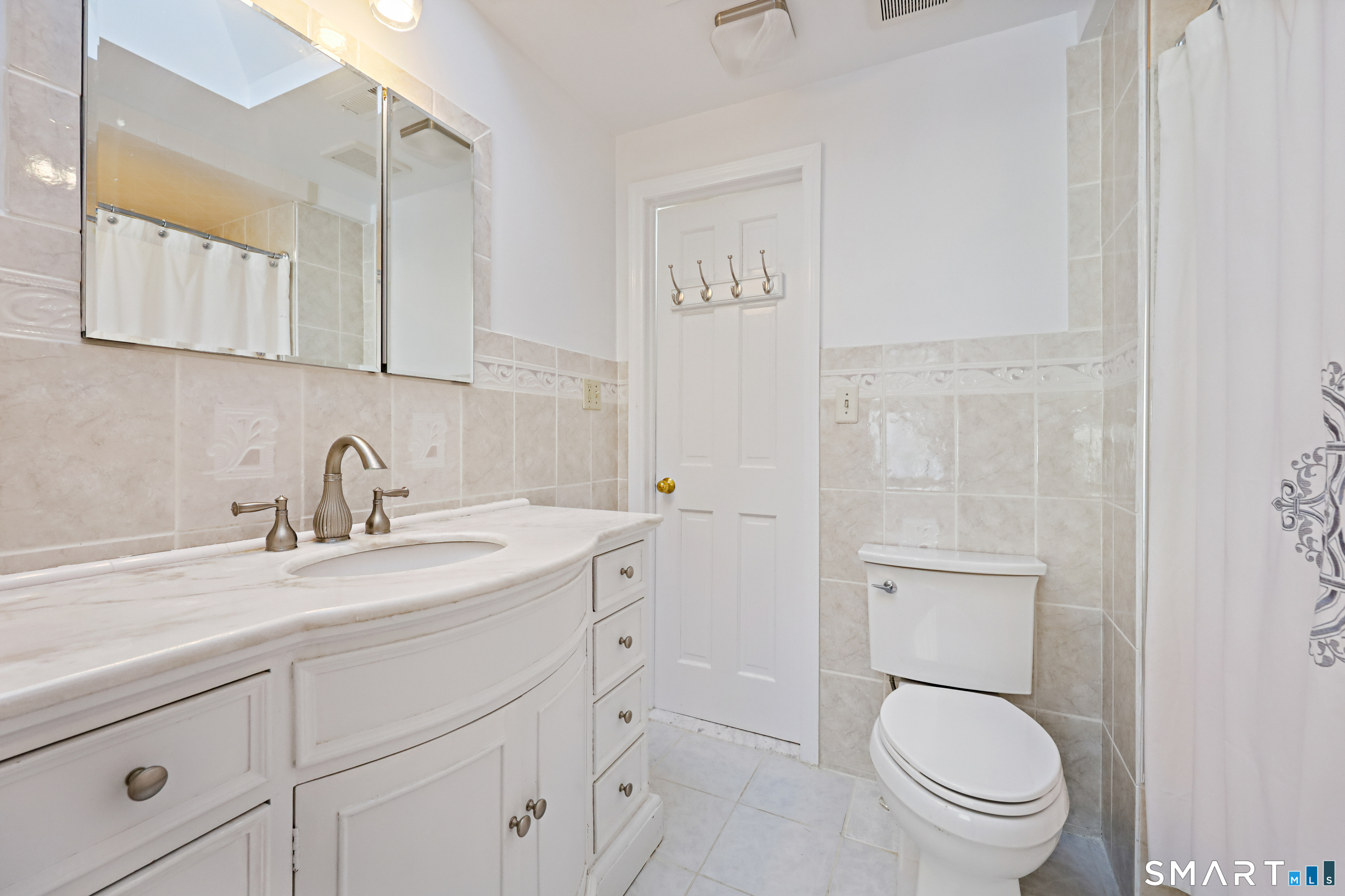 1215 Westover Road Stamford, CT 06902 - Photo 14 of 27 a bathroom with a granite countertop toilet sink and mirror