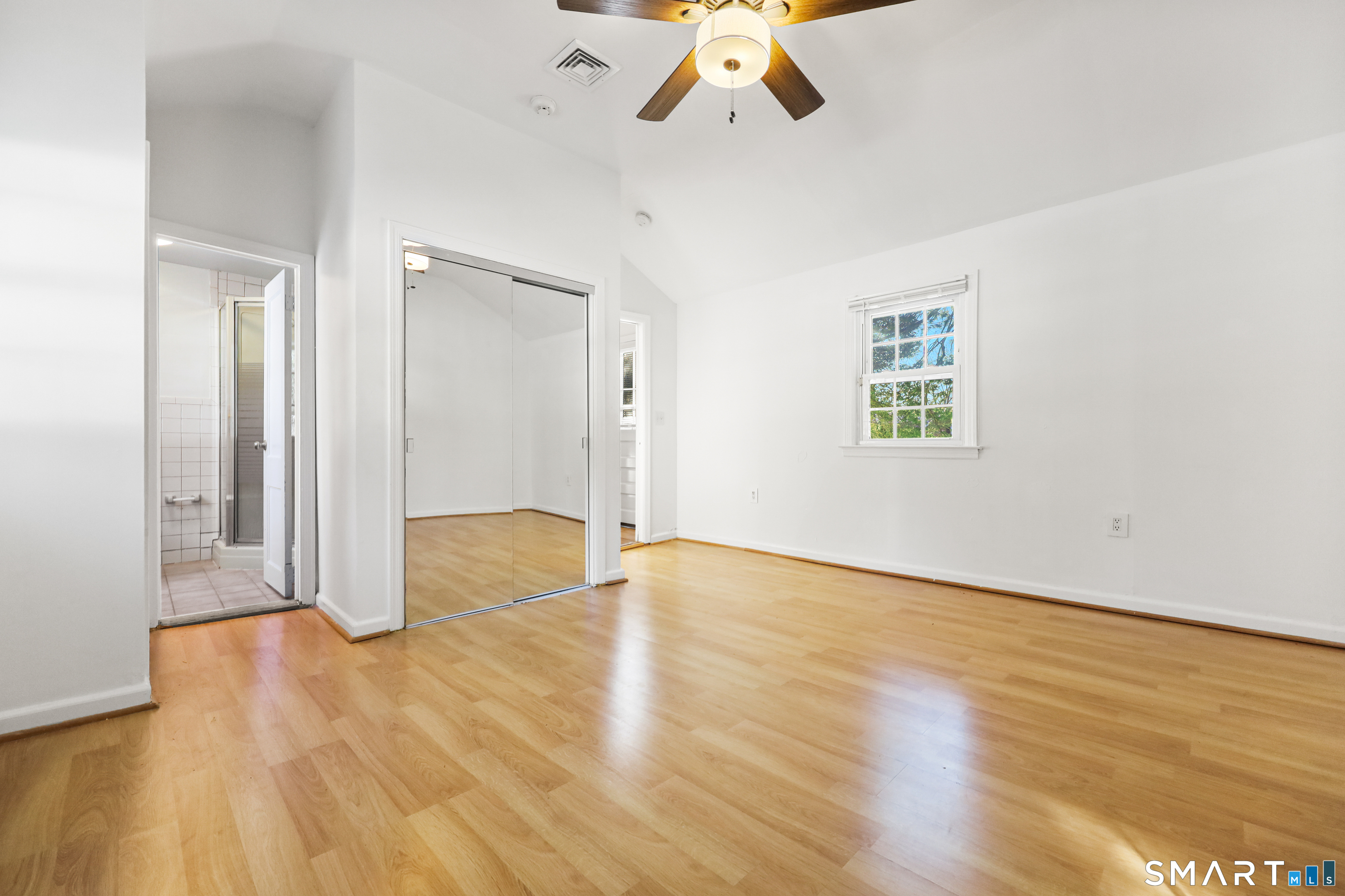 1215 Westover Road Stamford, CT 06902 - Photo 17 of 27 an empty room with wooden floor chandelier fan and windows