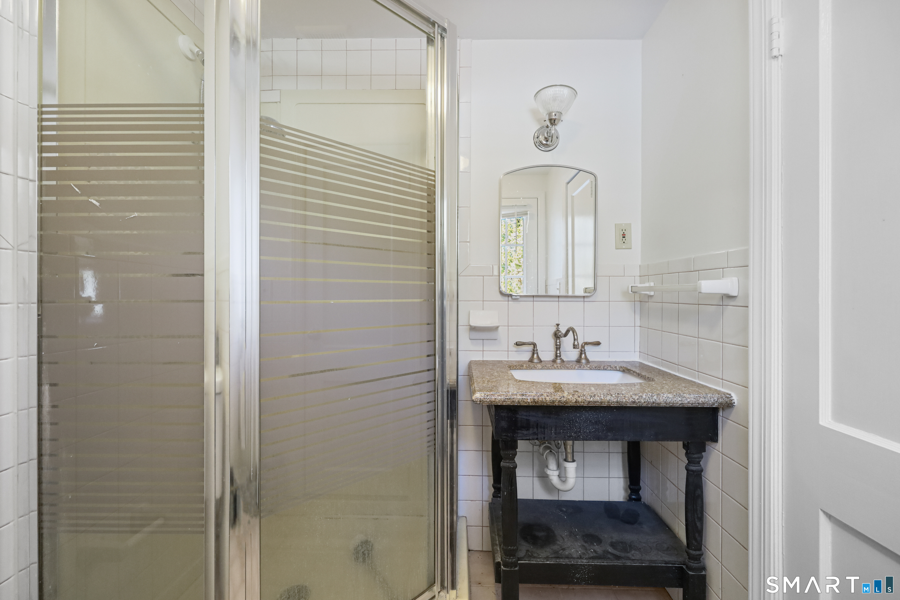 1215 Westover Road Stamford, CT 06902 - Photo 18 of 27 a bathroom with a sink and a mirror