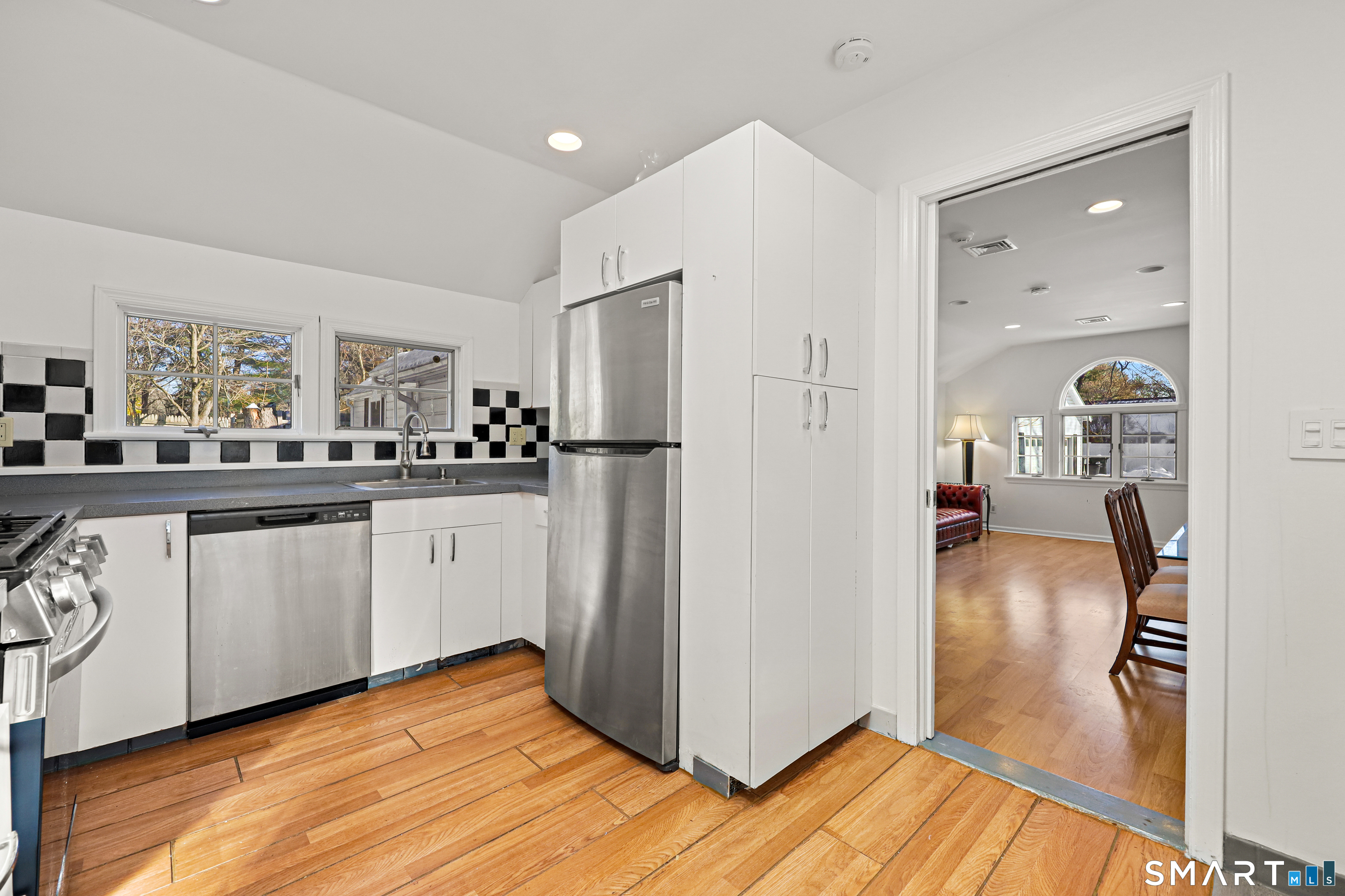 1215 Westover Road Stamford, CT 06902 - Photo 6 of 27 a kitchen with granite countertop a refrigerator a sink and white cabinets