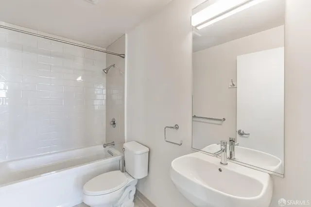 a bathroom with a bathtub shower sink vanity mirror and toilet