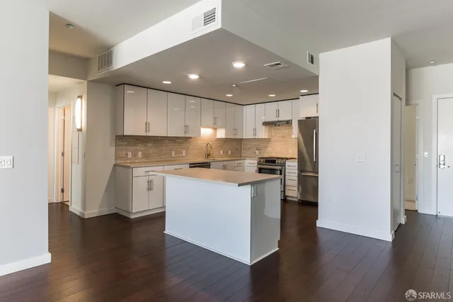 a kitchen with a refrigerator and white cabinets