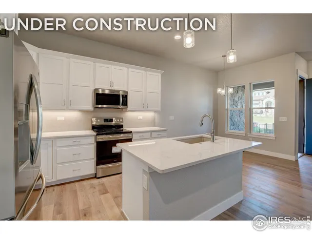 a kitchen with a sink stainless steel appliances and white cabinets