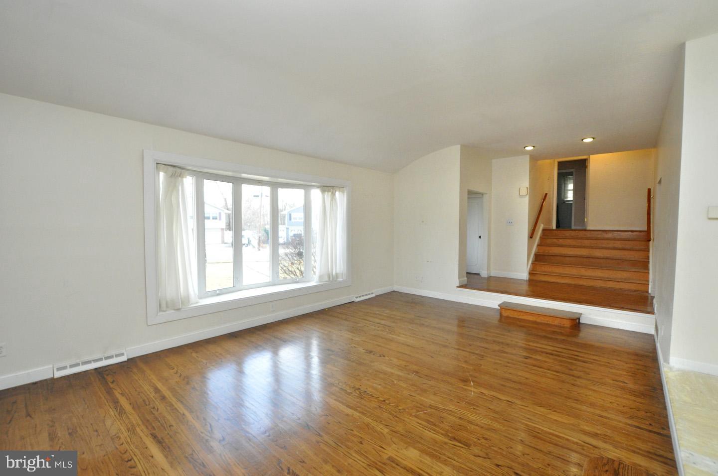 210 Philellena Road Cherry Hill, NJ 08034 - Photo 4 of 30 a view of an empty room with wooden floor and a window