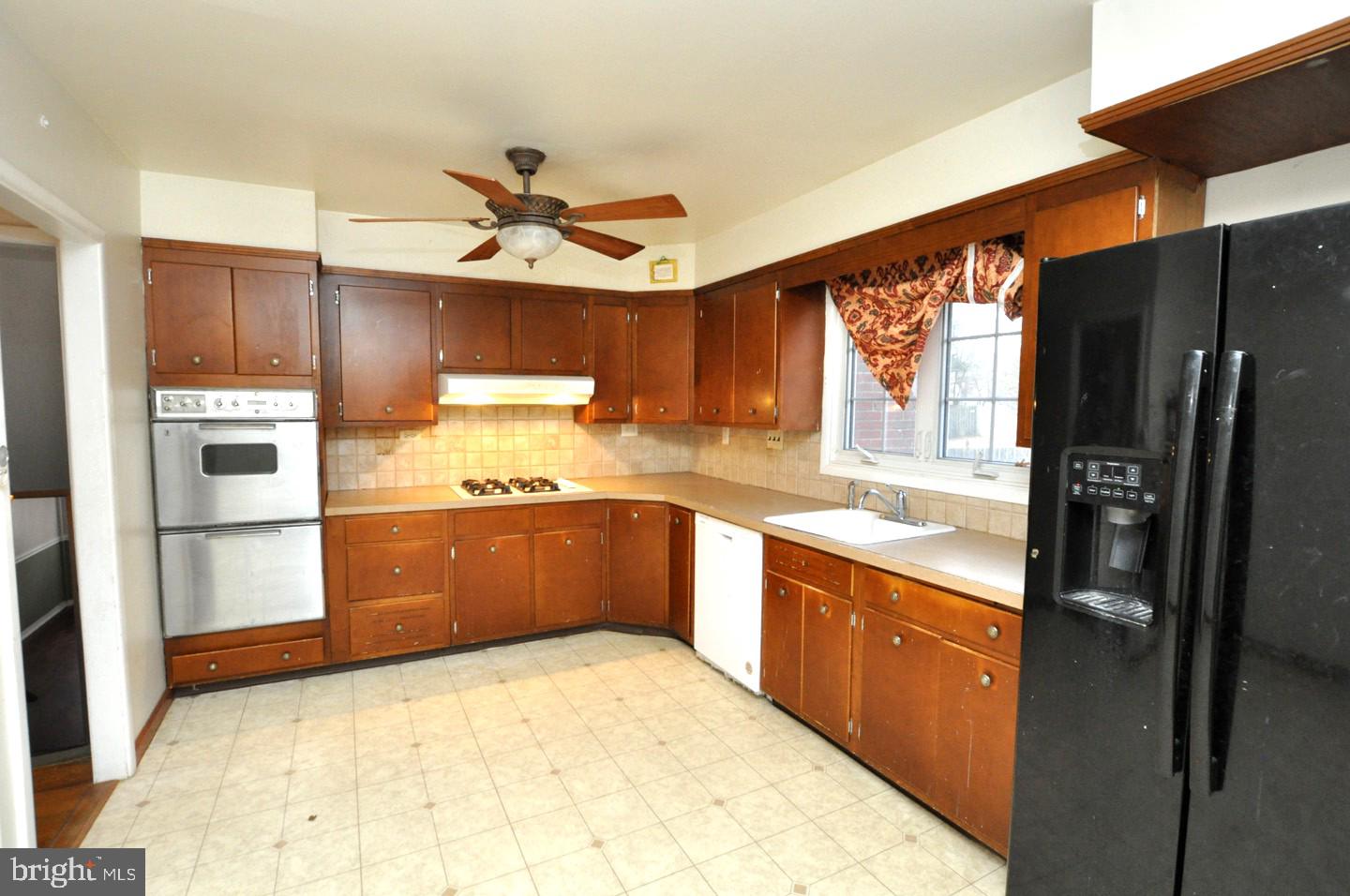 210 Philellena Road Cherry Hill, NJ 08034 - Photo 7 of 30 a kitchen with stainless steel appliances kitchen island granite countertop a refrigerator a sink dishwasher a stove with wooden cabinets and floor