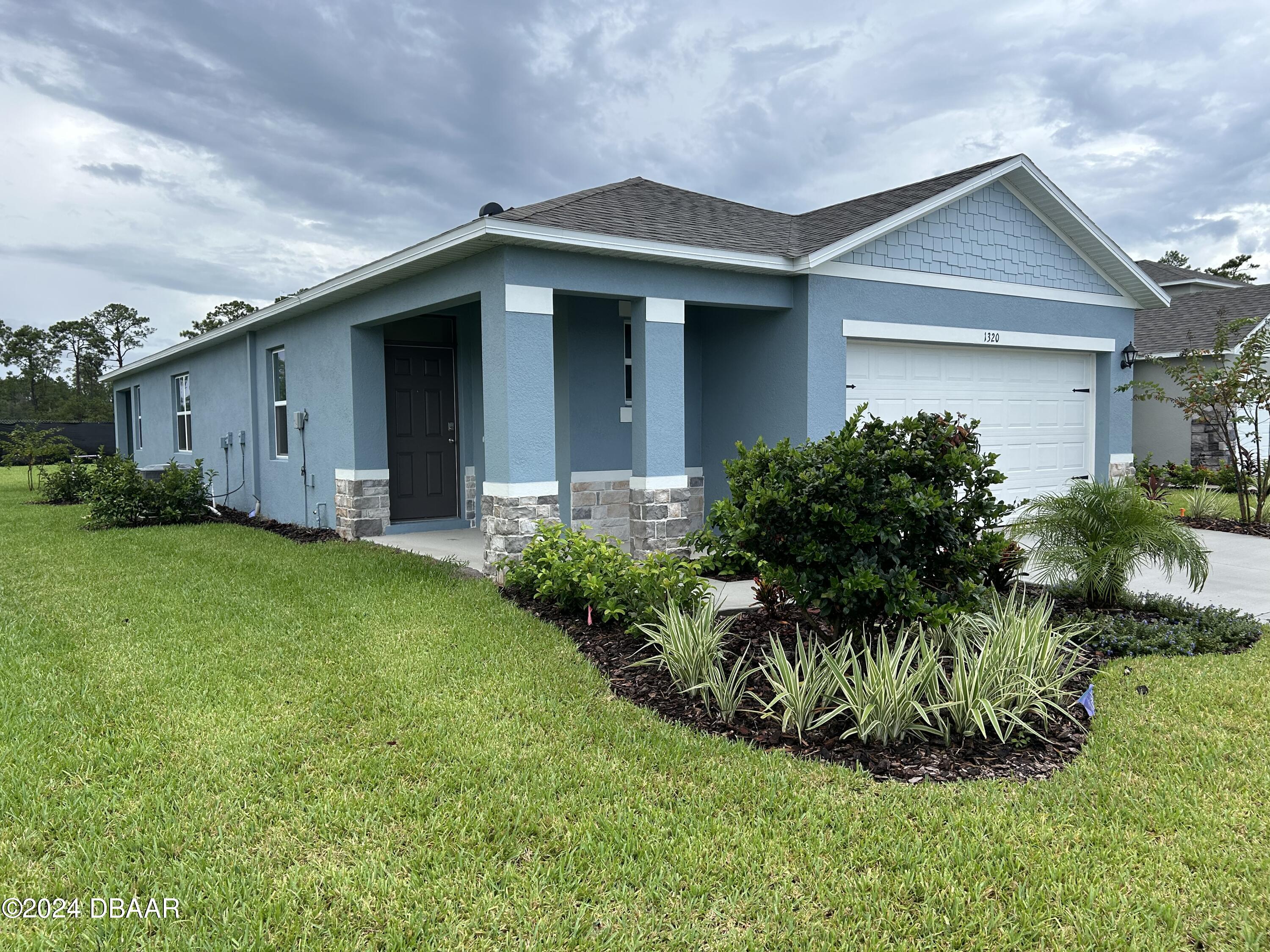 1320 Cork Drive Ormond Beach, FL 32174 - Photo 4 of 25 a front view of a house with a garden