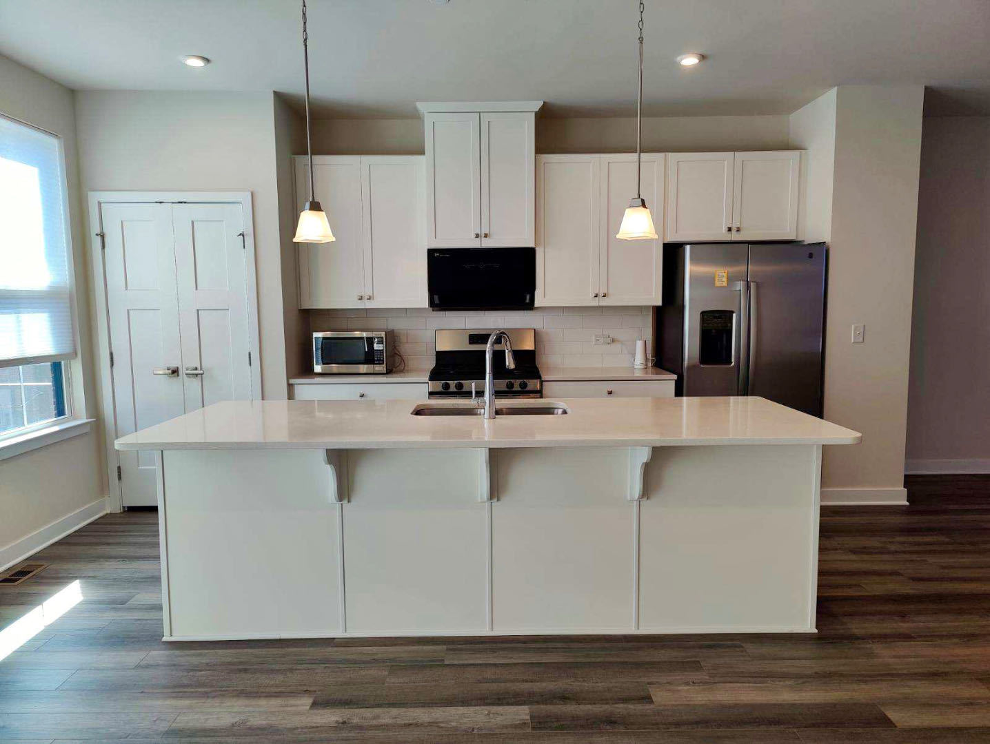 319 Elm Ct., Unit 319 Mount Prospect, IL 60056 - Photo 6 of 21 a kitchen with kitchen island white cabinets a sink a refrigerator and a stove