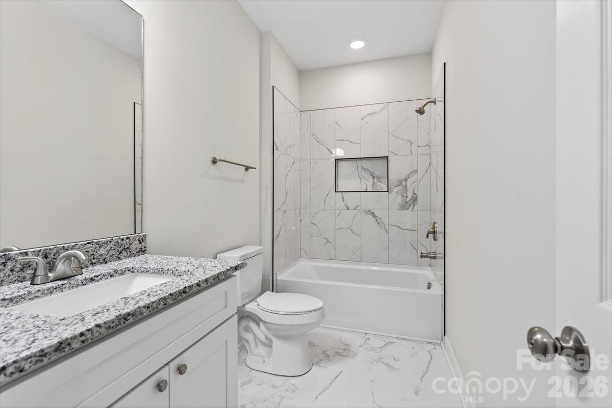 811 Craig Place Shelby, NC 28150 - Photo 24 of 28 a bathroom with a granite countertop sink a toilet and shower