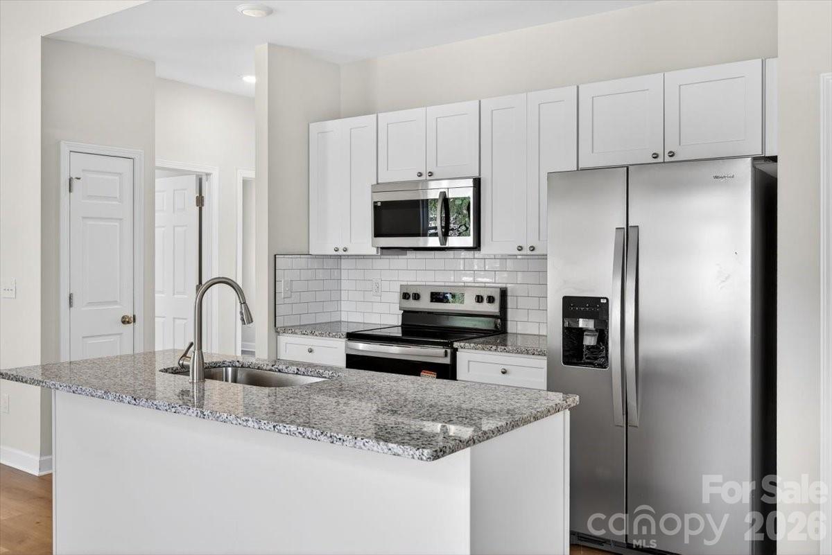 811 Craig Place Shelby, NC 28150 - Photo 7 of 28 a kitchen with stainless steel appliances granite countertop a sink a stove and a refrigerator