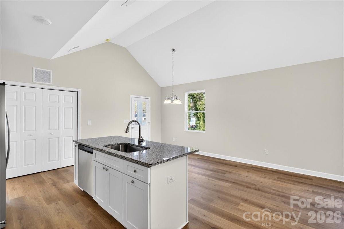 811 Craig Place Shelby, NC 28150 - Photo 9 of 28 a kitchen with granite countertop a sink and a stove with wooden floor