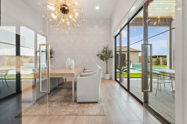 a dining room with glass top table and chairs