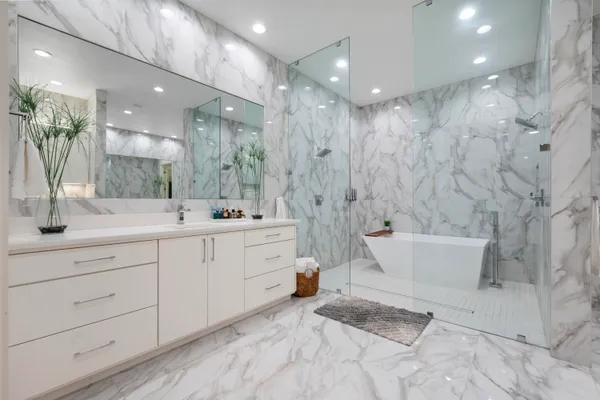 a bathroom with a double vanity sink a toilet a mirror and shower