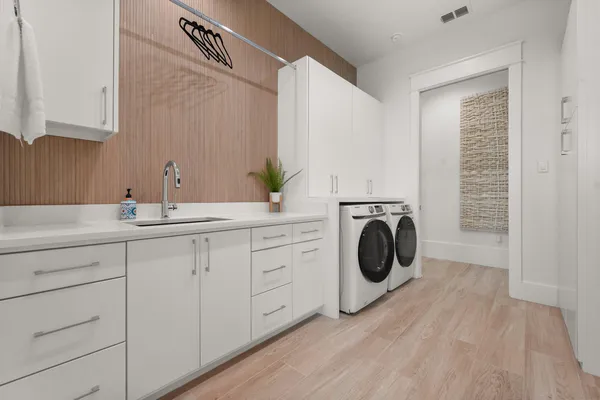 a utility room with sink dryer and washer