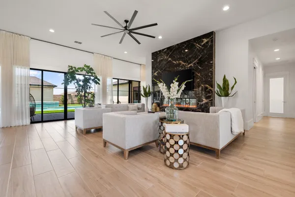 a living room with furniture a chandelier and a large window
