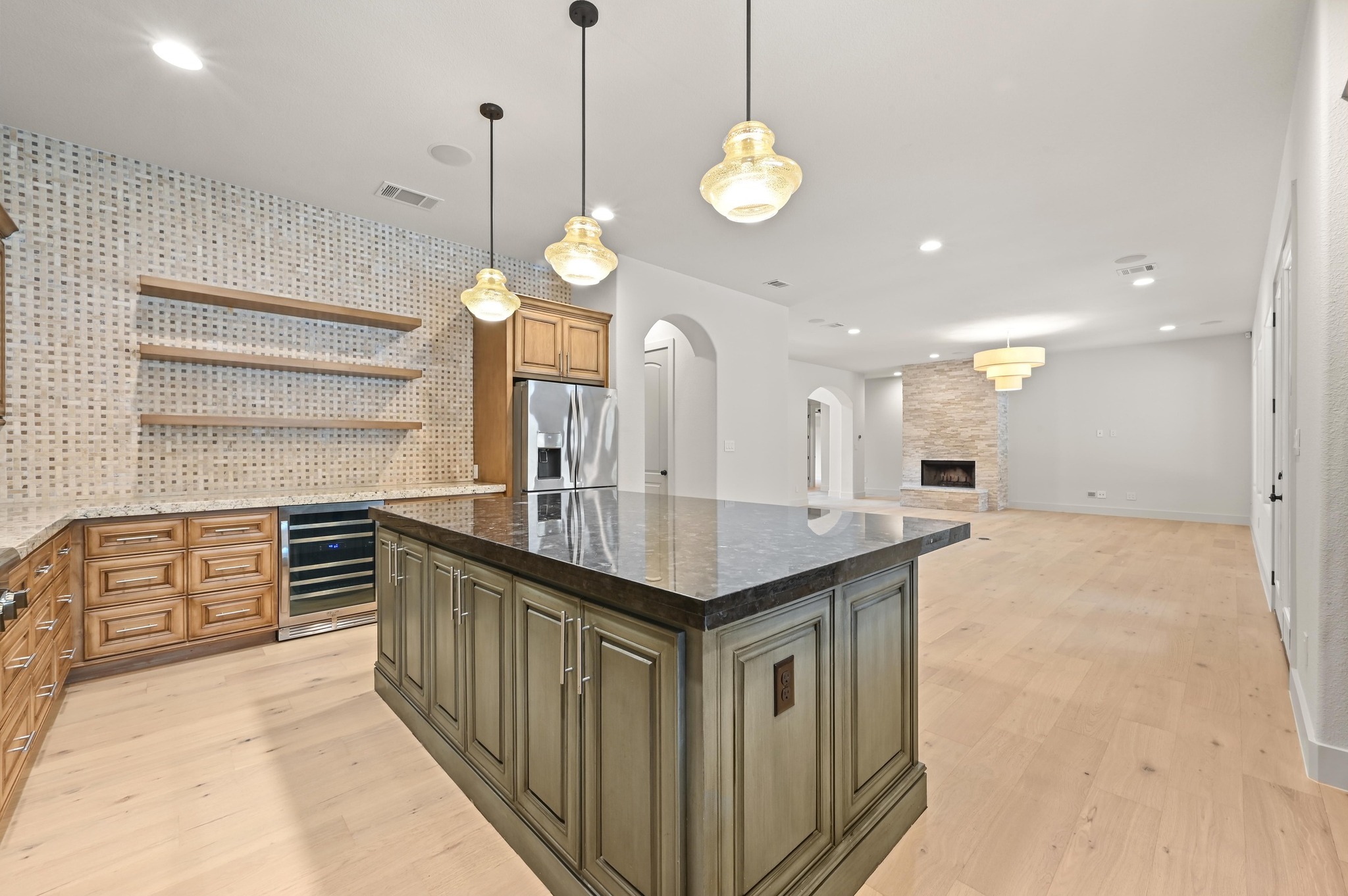 2800 Barton Point Drive Austin, TX 78733 - Photo 10 of 40 Two tone kitchen featuring open shelves, dual tone cabinetry, dark stone countertops, a kitchen island, and wine cooler