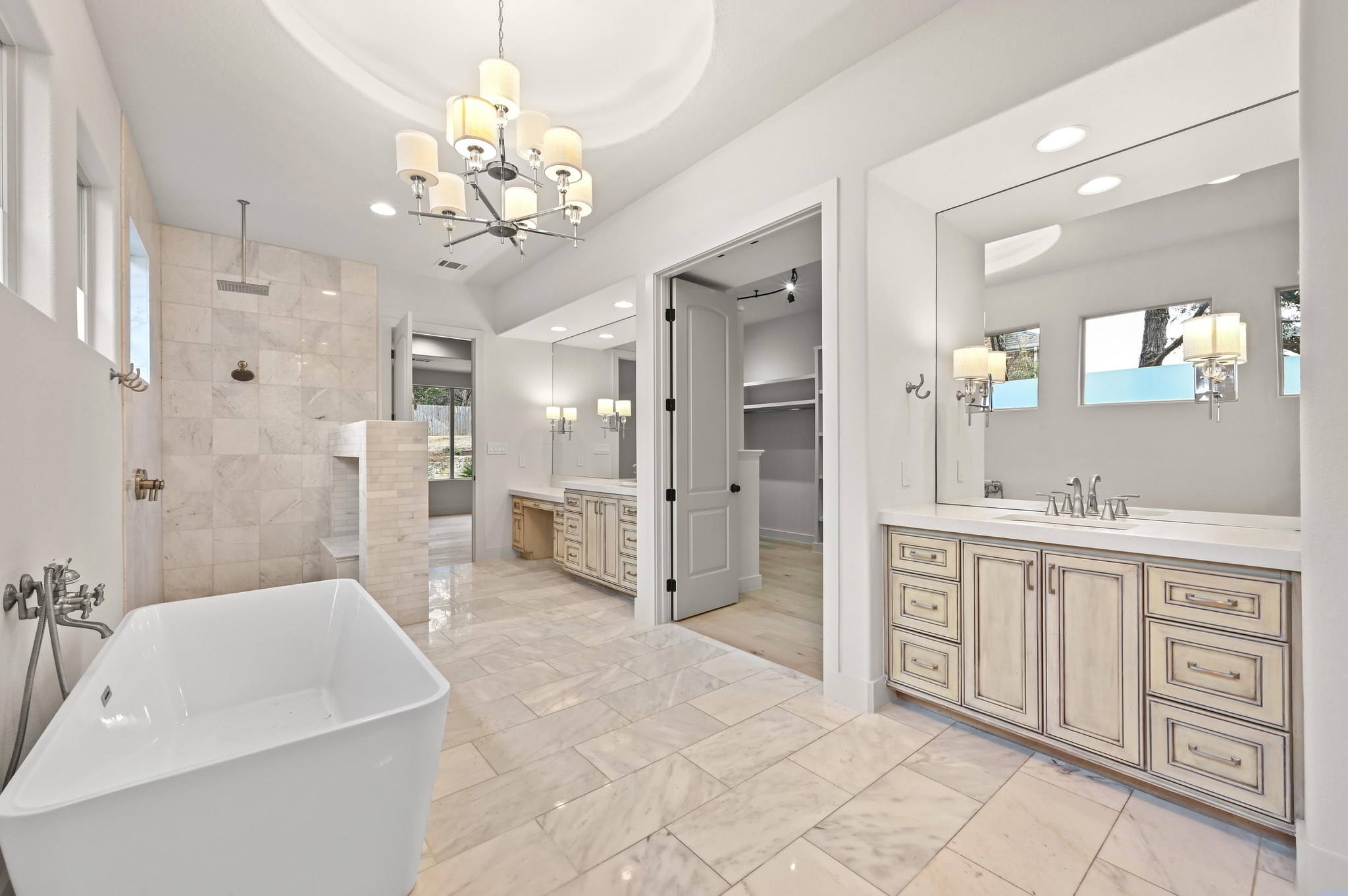 2800 Barton Point Drive Austin, TX 78733 - Photo 15 of 40 Full bathroom featuring two vanities, a walk in shower, a spacious closet, suspended lighting, and a freestanding tub