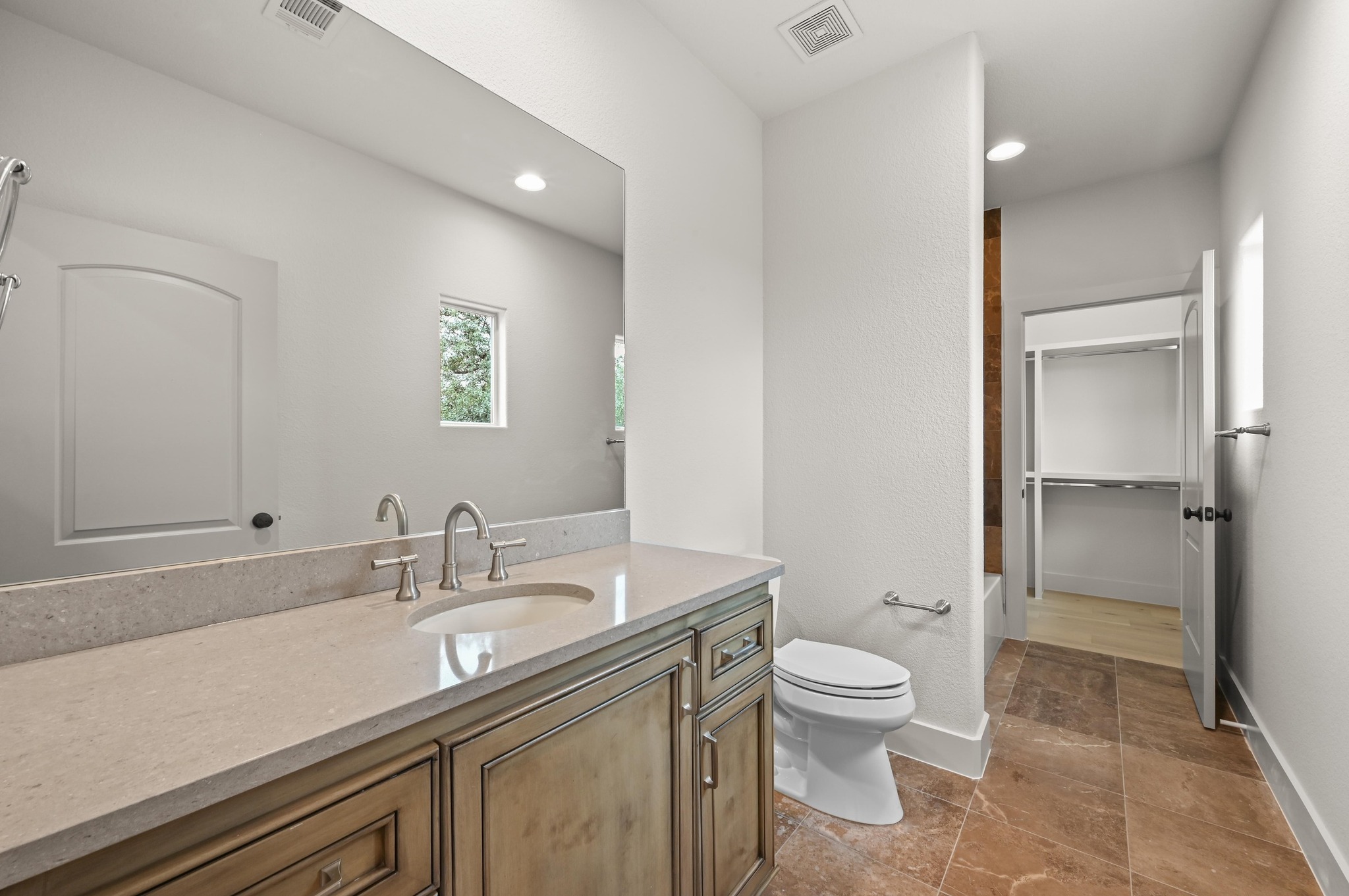 2800 Barton Point Drive Austin, TX 78733 - Photo 26 of 40 Full bathroom featuring vanity, stone tile floors, shower / tub combination, and a walk in closet