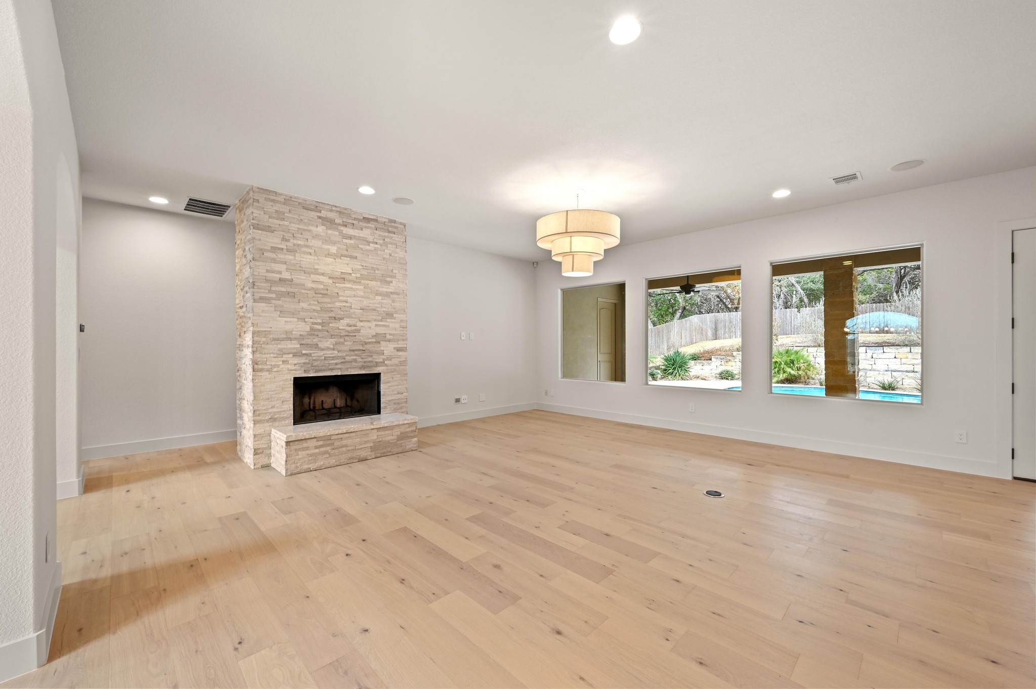 2800 Barton Point Drive Austin, TX 78733 - Photo 6 of 40 Unfurnished living room with a fireplace, light wood finished floors, and recessed lighting