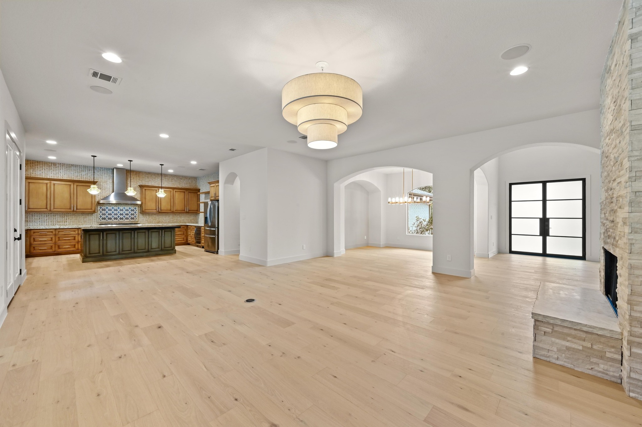 2800 Barton Point Drive Austin, TX 78733 - Photo 40 of 40 Dual tone kitchen featuring open floor plan, pendant lighting, a center island, a fireplace, and two tone cabinets