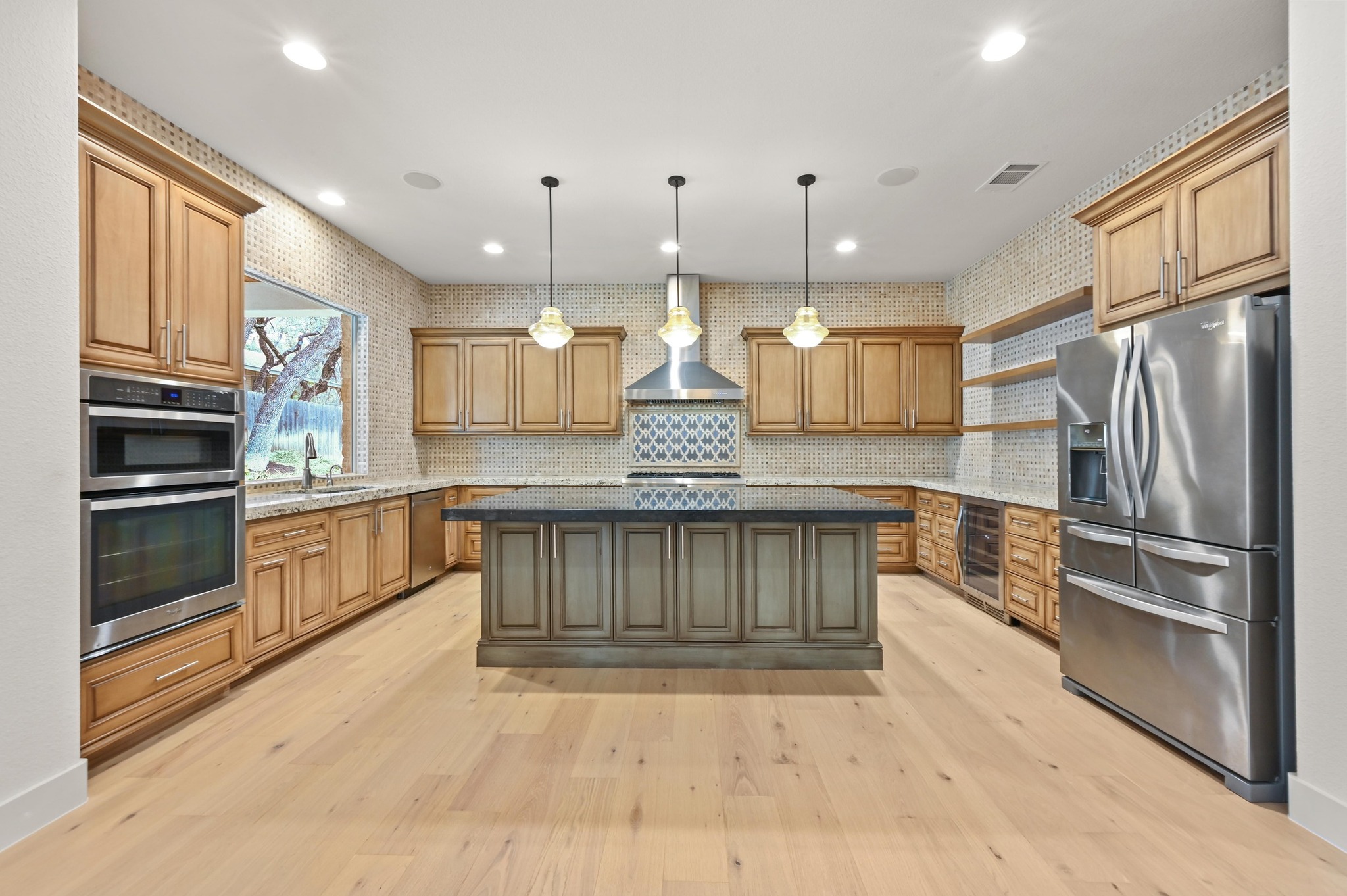 2800 Barton Point Drive Austin, TX 78733 - Photo 8 of 40 Kitchen featuring open shelves, stainless steel appliances, hanging light fixtures, dark stone countertops, and light wood-style flooring