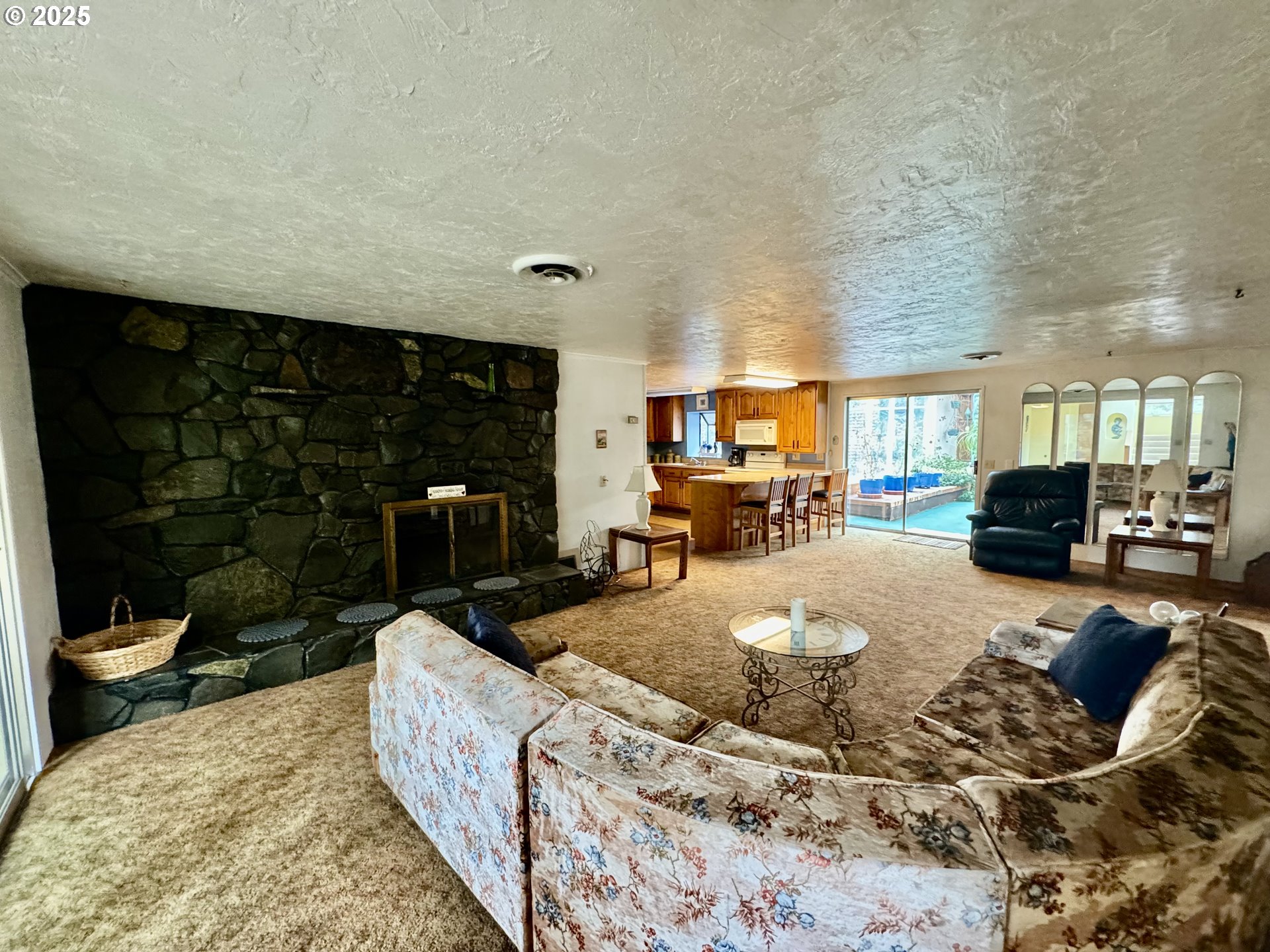 4990 Mitchell Loop Road Florence, OR 97439 - Photo 16 of 35 a living room with furniture a red rug and a fireplace