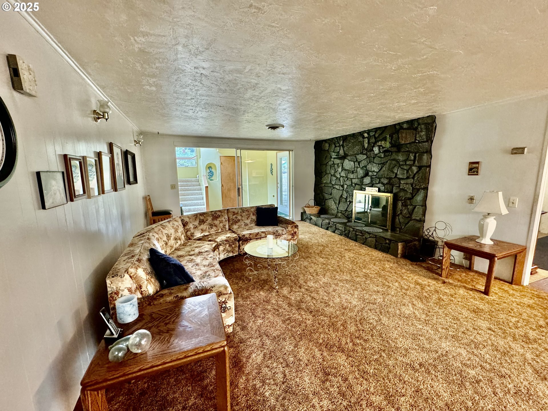 4990 Mitchell Loop Road Florence, OR 97439 - Photo 17 of 35 a living room with furniture a fireplace and a flat screen tv
