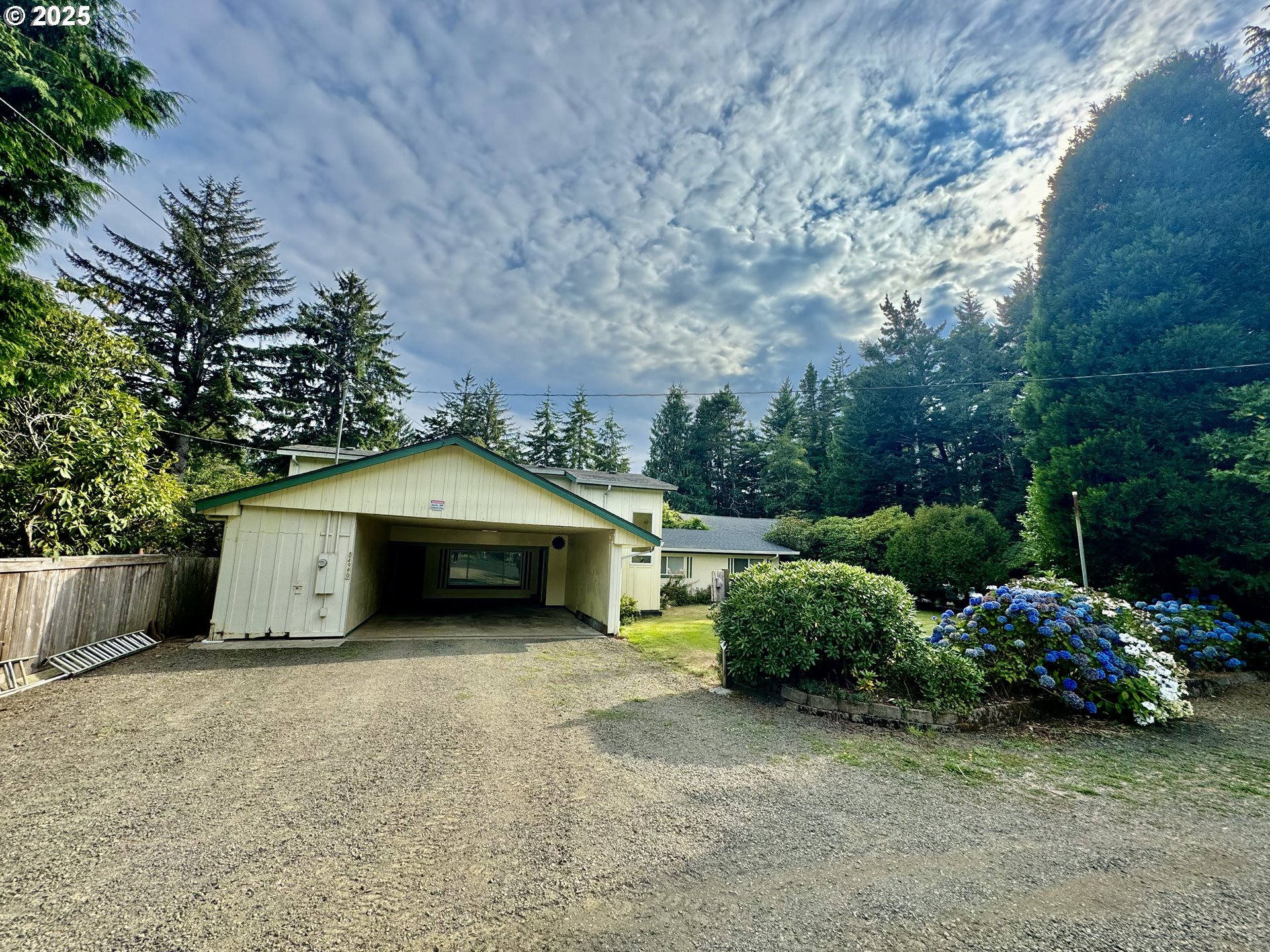 4990 Mitchell Loop Road Florence, OR 97439 - Photo 2 of 35 a white house with a large tree and a yard