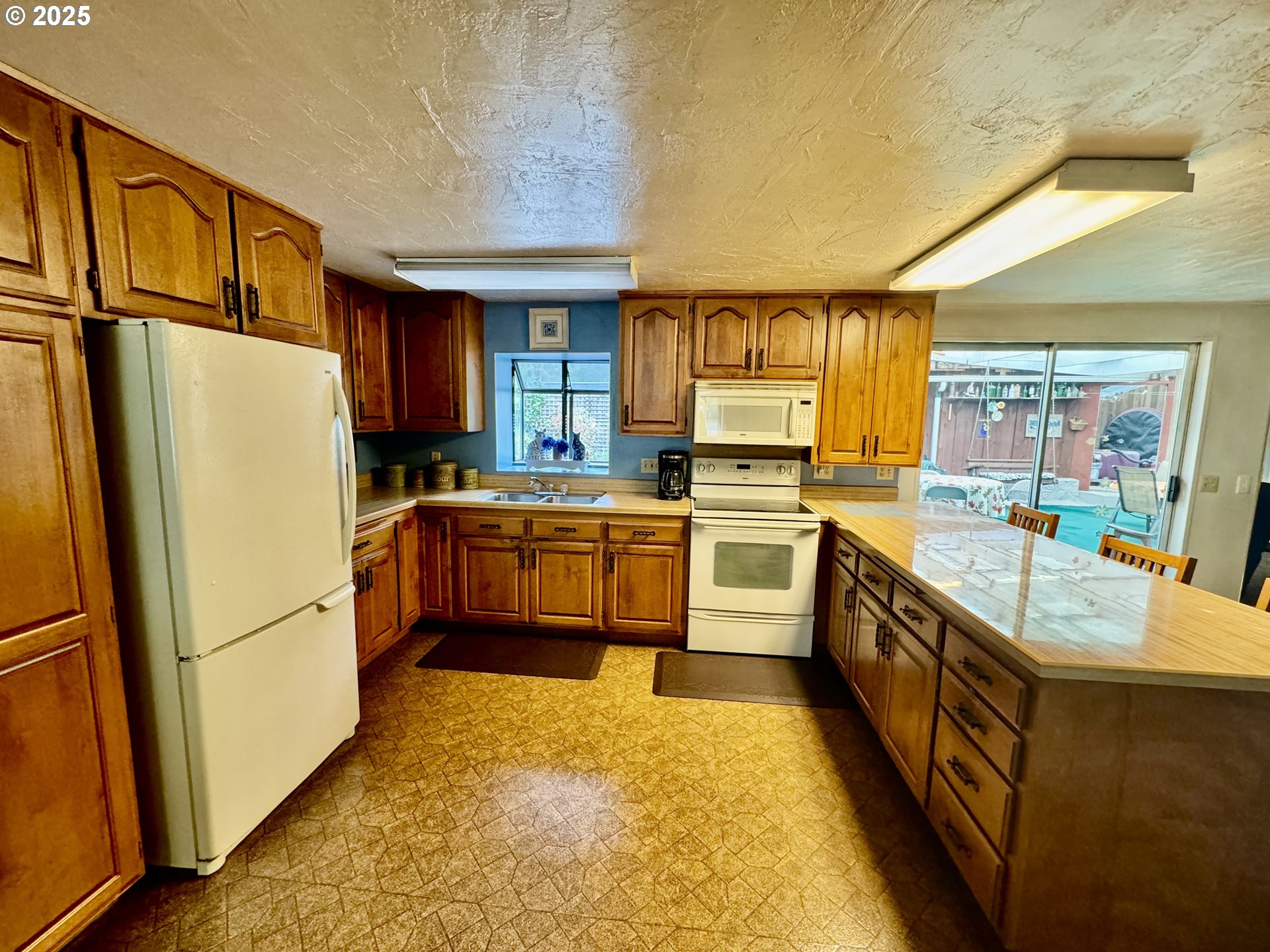 4990 Mitchell Loop Road Florence, OR 97439 - Photo 10 of 35 a kitchen with stainless steel appliances a refrigerator sink and cabinets