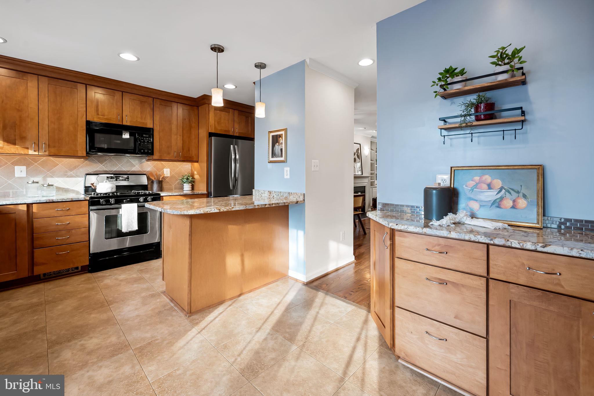 612 Pubped Way Baltimore, MD 21230 - Photo 12 of 55 a kitchen with stainless steel appliances granite countertop a stove top oven a sink dishwasher a dining table and chairs with wooden floor