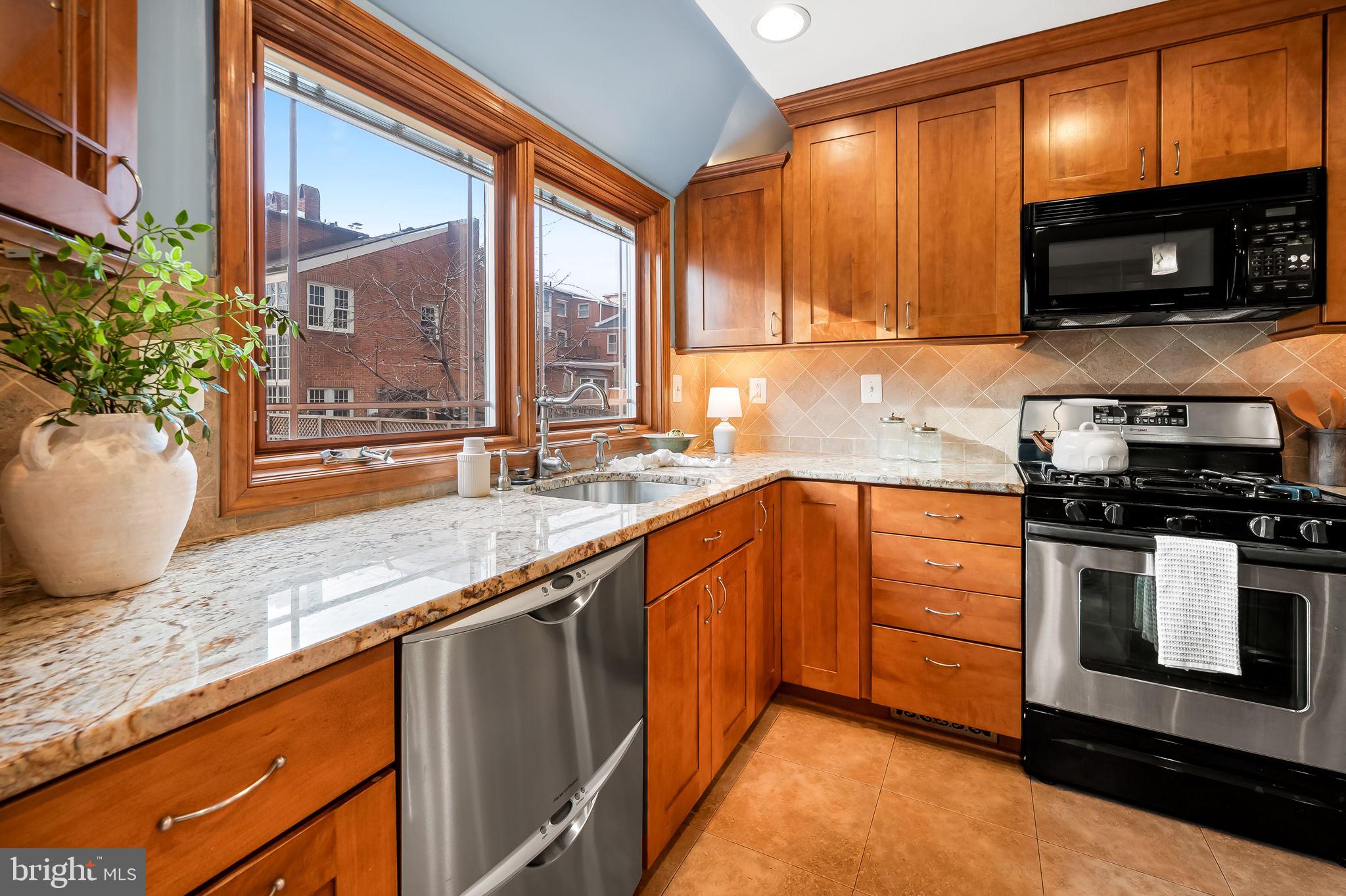 612 Pubped Way Baltimore, MD 21230 - Photo 14 of 55 a kitchen with stainless steel appliances granite countertop a sink a stove and a microwave