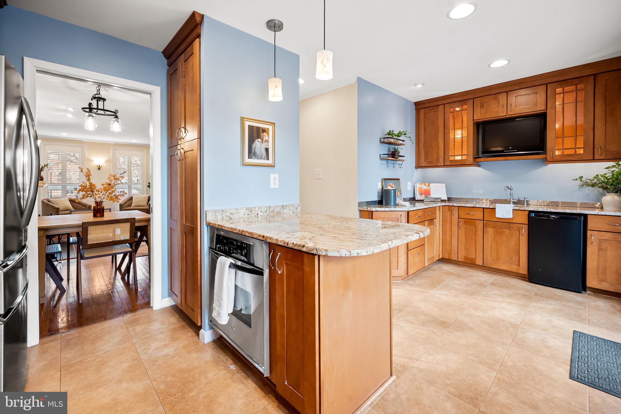 612 Pubped Way Baltimore, MD 21230 - Photo 16 of 55 a kitchen with stainless steel appliances granite countertop a stove top oven a sink dishwasher a dining table and chairs with wooden floor