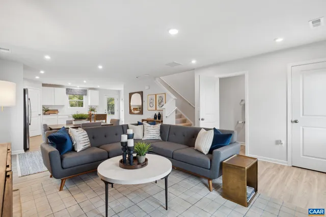 a living room with furniture and a wooden floor