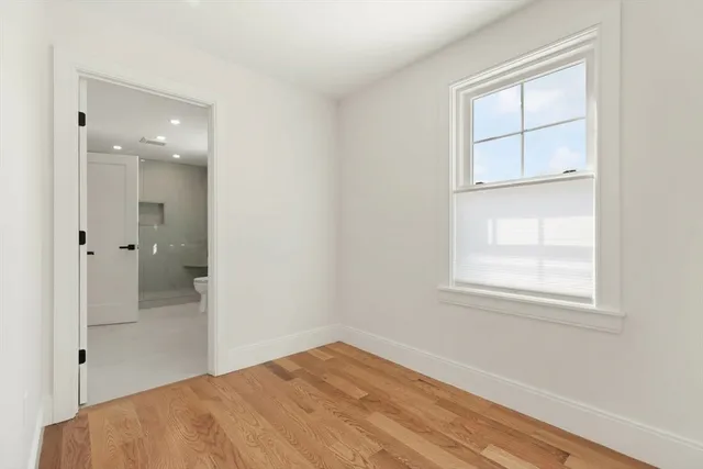 an empty room with window and mirror