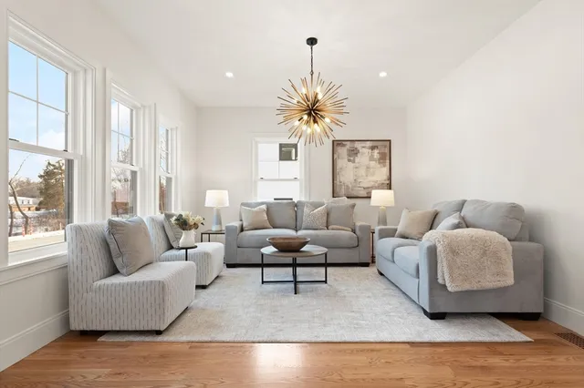 a living room with furniture and a chandelier