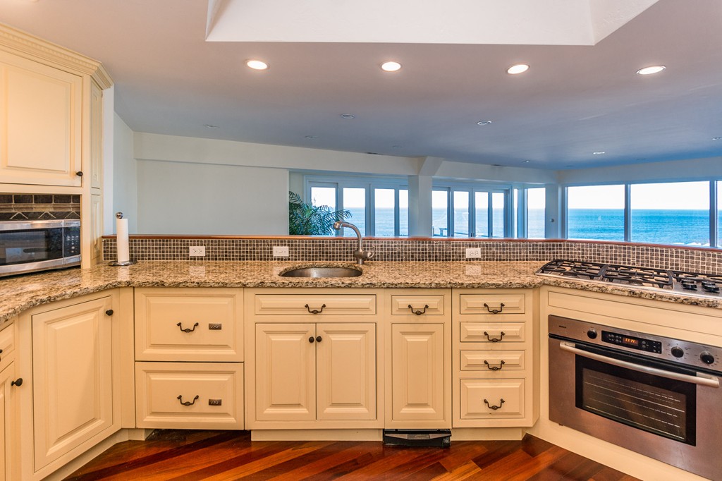 63 Oceanside Drive, Unit 63 Hull, MA 02045 - Photo 15 of 30 a kitchen with granite countertop a stove oven and sink