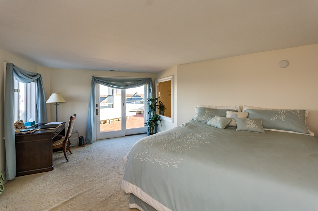 63 Oceanside Drive, Unit 63 Hull, MA 02045 - Photo 20 of 30 a bedroom with a bed and wooden floor