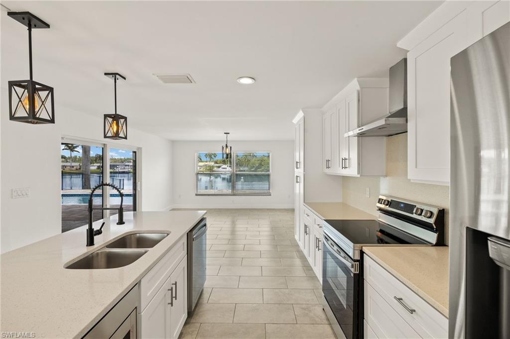 13846 Sleepy Hollow Lane Fort Myers, FL 33905 - Photo 11 of 46 a kitchen with stainless steel appliances a sink stove and refrigerator