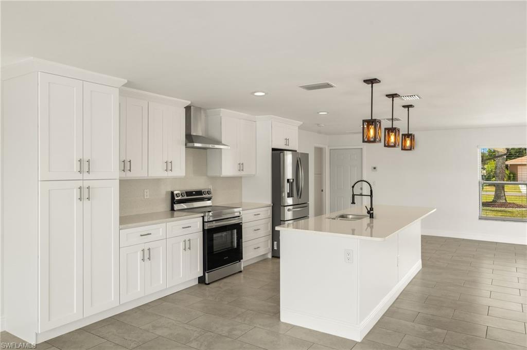 13846 Sleepy Hollow Lane Fort Myers, FL 33905 - Photo 17 of 46 a kitchen with a sink a stove and refrigerator