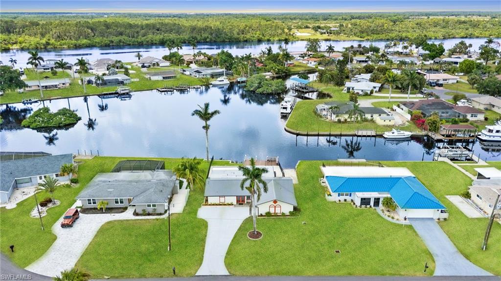 13846 Sleepy Hollow Lane Fort Myers, FL 33905 - Photo 2 of 46 an aerial view of a swimming pool with outdoor seating and yard