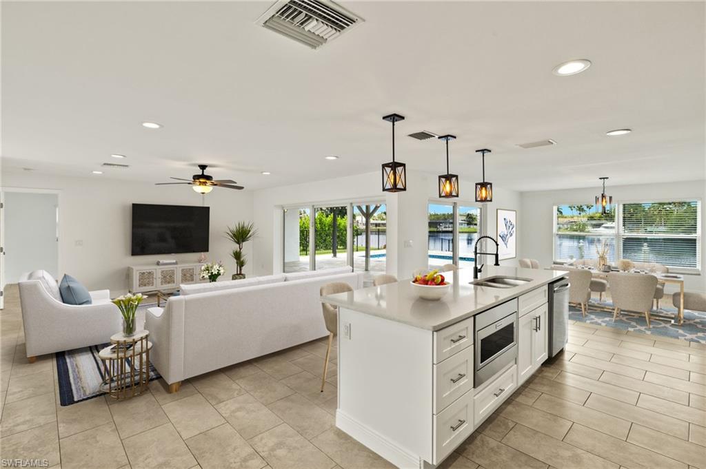 13846 Sleepy Hollow Lane Fort Myers, FL 33905 - Photo 4 of 46 a living room with stainless steel appliances kitchen island furniture and a flat screen tv