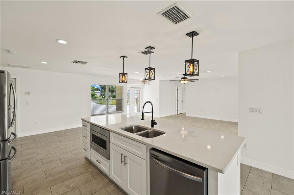 13846 Sleepy Hollow Lane Fort Myers, FL 33905 - Photo 10 of 46 a kitchen with stainless steel appliances granite countertop a sink and a refrigerator
