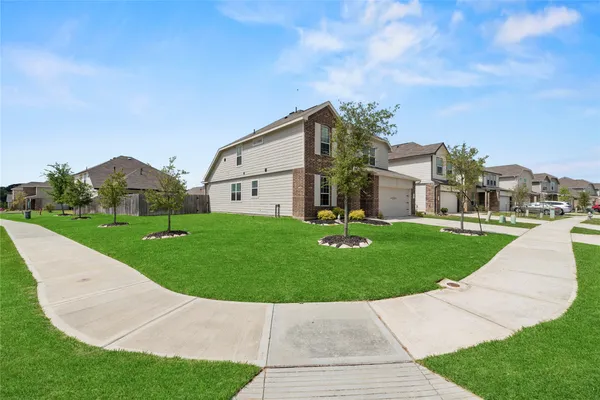 a front view of a house with a garden and yard