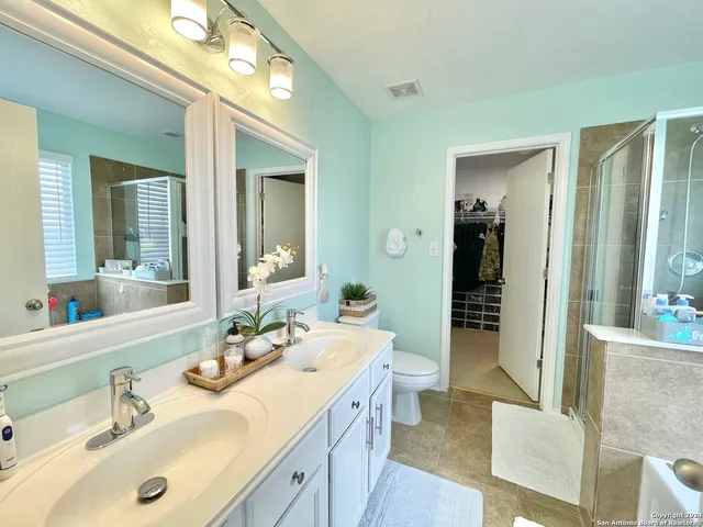 a bathroom with a sink vanity granite tub and a mirror