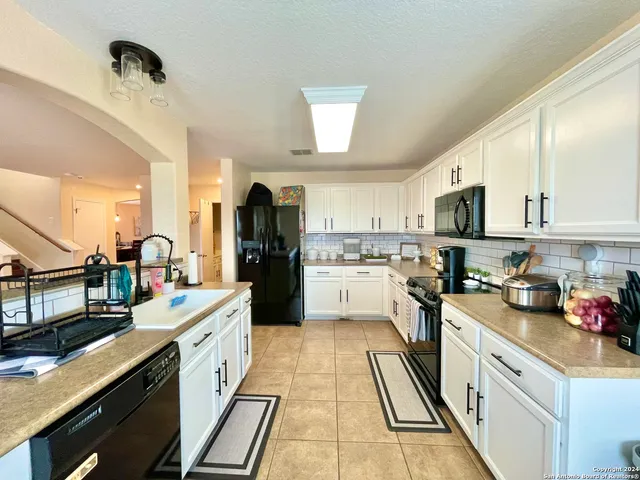 a kitchen with white cabinets and appliances