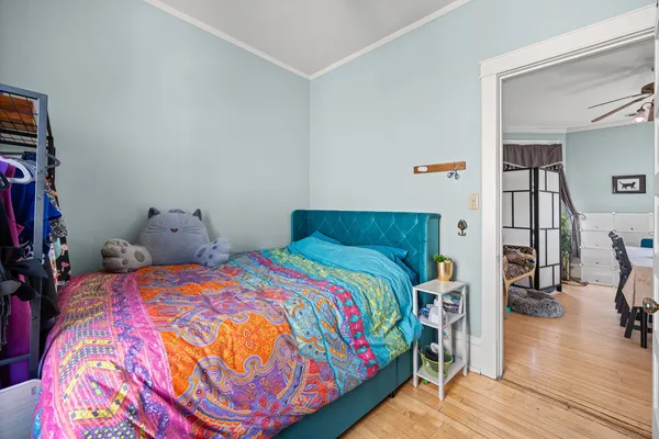 a bedroom with a bed and wooden floor