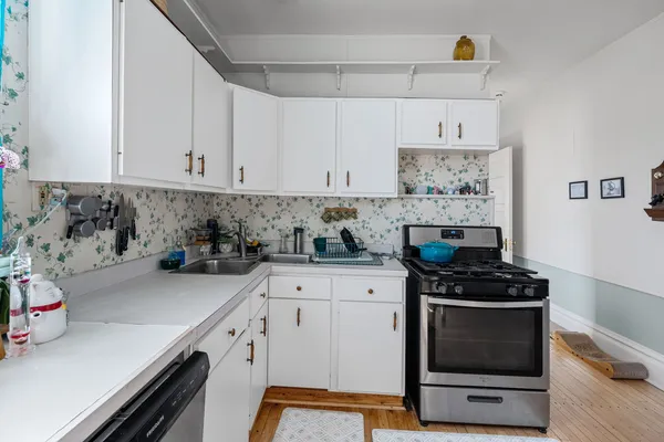 a kitchen with stainless steel appliances a stove a sink and cabinets