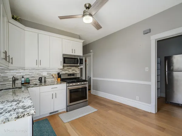 a kitchen with stainless steel appliances granite countertop a stove top oven a sink and a refrigerator