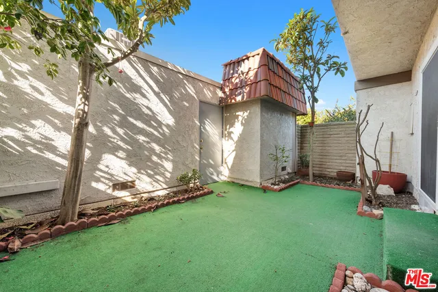 a backyard of a house with table and chairs