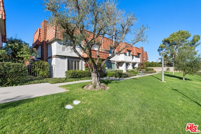 a porch with a tree in the grass